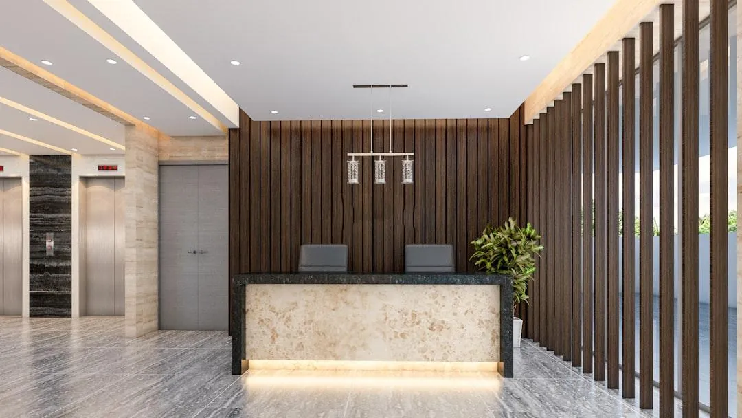 Finished commercial office lobby with wood slat walls and a stone reception desk