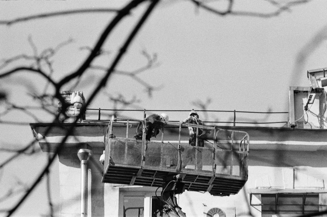 Painters using an aerial lift on a commercial building exterior