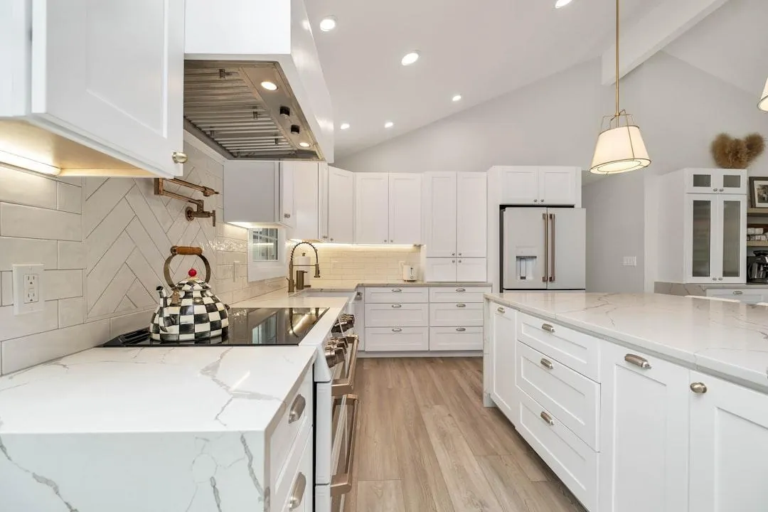 Kitchen with freshly painted white cabinets and a marble-look countertop