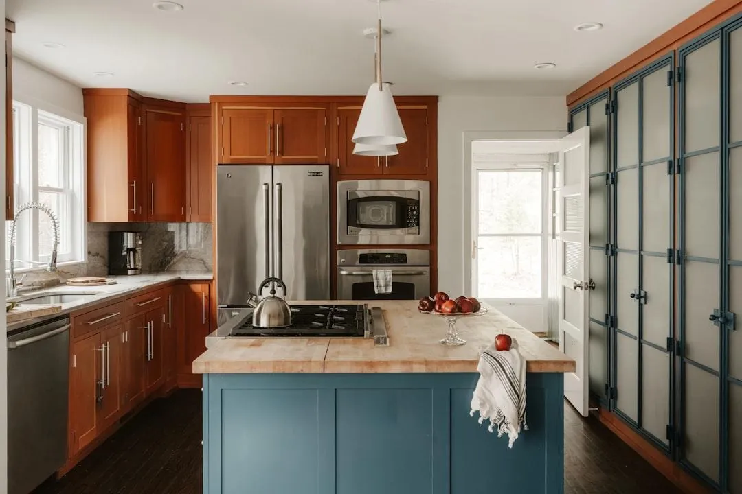 Kitchen with wood cabinets and a painted blue island