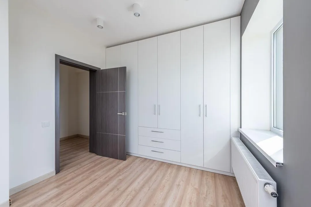 Bright entry with floor-to-ceiling white painted storage cabinets